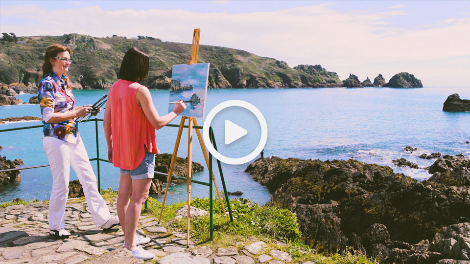 two women painting a seascape of Guernsey
